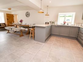 A kitchen with a dining table and chairs counter at Isfryn