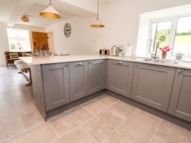 A kitchen with gray cabinets and a sink at Isfryn