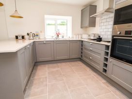 A kitchen with cabinets and appliances at Isfryn