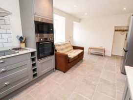 A kitchen with appliances and a couch at Isfryn