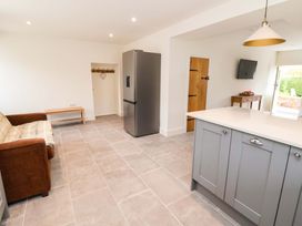 A kitchen with a refrigerator and a sofa at Isfryn