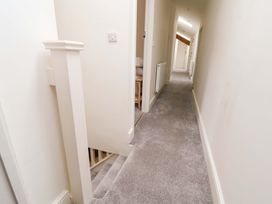 A hallway with a staircase and doors at Isfryn