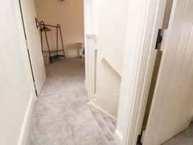 A hallway with a staircase and storage at Isfryn 
