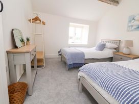 A bedroom with two beds and a mirror at Isfryn in 