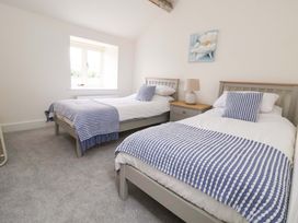 A bedroom with two beds and a lamp at Isfryn