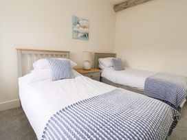 A bedroom with two single beds and a nightstand at Isfryn