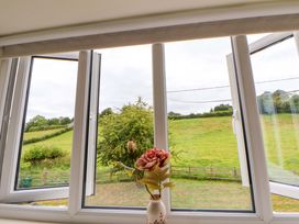A view of a field through opened windows at Isfryn 