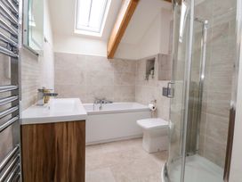 A bathroom with a bathtub, shower, toilet, and sink at Isfryn