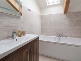 A bathroom with a bathtub and sink at Isfryn
