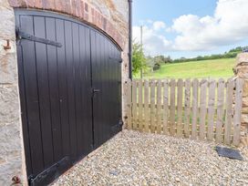 A black door and wooden fence in an outdoor area at Isfryn 