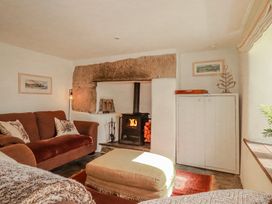 A living room with a fireplace and sofa at Poldue House Watergate near Camelford