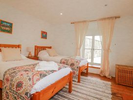 A bedroom with two beds and a window at Poldue House Watergate near Camelford