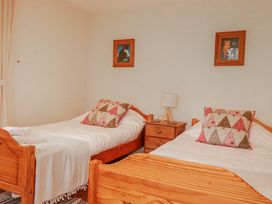 A bedroom with two beds and wall art at Poldue House in Watergate near Camelford