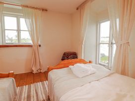 A bedroom with two beds and a window at Poldue House Watergate near Camelford
