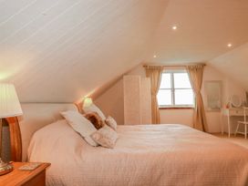 A bedroom with a bed and dressing table at Poldue House in Watergate near Camelford