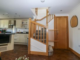 A kitchen with a staircase and cabinets at 2 Court Cottage in Dartmouth