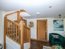 A hallway with stairs and a mirror at 2 Court Cottage in Dartmouth