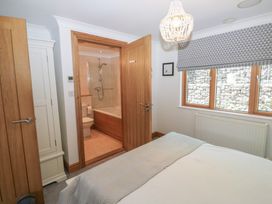 A bedroom with a bed and an adjoining bathroom at 2 Court Cottage Dartmouth