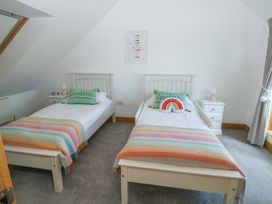 A bedroom with two beds and bedside tables at 2 Court Cottage in Dartmouth