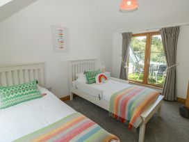 A bedroom with two beds and a window at 2 Court Cottage Dartmouth