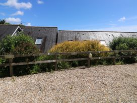 A view of two houses with a gravel area and bushes at 2 Court Cottage in Dartmouth