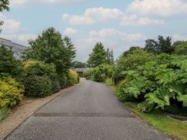 A residential street lined with bushes and trees at 2 Court Cottage in Dartmouth