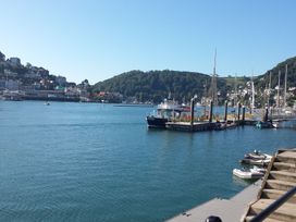 A harbor with boats docked and hills in the background at 2 Court Cottage, Hillfield Village in Dartmouth