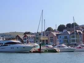 A marina with boats and colorful houses at 2 Court Cottage, Hillfield Village Dartmouth