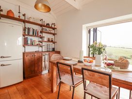 A kitchen with a dining table and chairs at Roughtor Barn in Poldue near Camelford