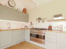 A kitchen with cabinets and stove at Roughtor Barn Poldue near Camelford