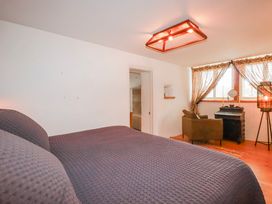A bedroom with a bed and an armchair at Roughtor Barn Poldue near Camelford