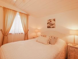 A bedroom with a bed and lamps at Roughtor Barn in Poldue near Camelford