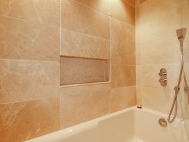 A bathtub and shower setup in a bathroom at Roughtor Barn Poldue near Camelford