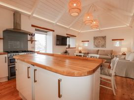 A kitchen with an island and stove at Logan Barn in Poldue near Camelford