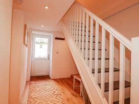 A hallway with a staircase and door at Logan Barn in Poldue near Camelford