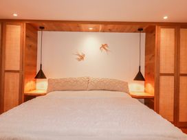 A bedroom with a bed and bedside lamps at Logan Barn in Poldue near Camelford