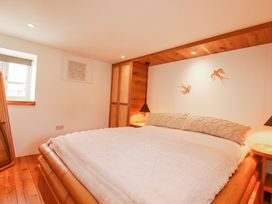 A bedroom with a bed and bedside lamps at Logan Barn in Poldue near Camelford