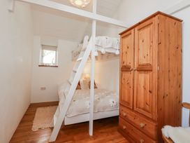 A bedroom with a bunk bed and a double bed at Logan Barn in Poldue near Camelford