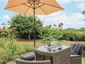 An outdoor seating area with a table and chairs at The West Wing in Potterne
