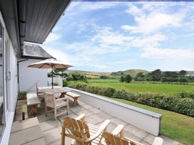 An outdoor area with a table and chairs at Seaworthy in Daymer Bay