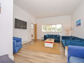 A living room with a television and seating at Seaworthy in Daymer Bay