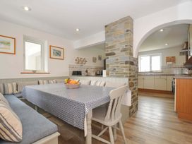 A dining room with a table and bench seating at Seaworthy Daymer Bay