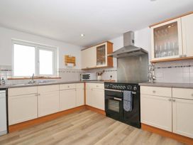 A kitchen with cabinets and appliances at Seaworthy in Daymer Bay