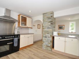 A kitchen with oven, sink, and cabinets at Seaworthy in Daymer Bay