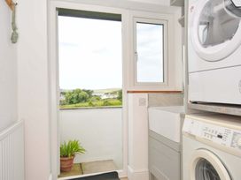 A laundry room with a washer dryer and sink at Seaworthy in Daymer Bay