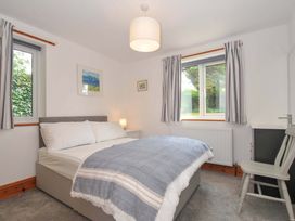 A bedroom with a bed and lamp at Seaworthy in Daymer Bay