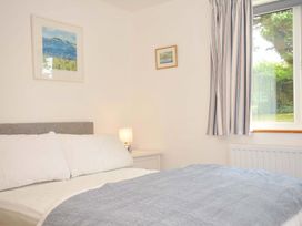 A bedroom with a bed and paintings at Seaworthy in Daymer Bay