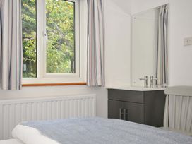 A bedroom with a window and a mirror at Seaworthy in Daymer Bay