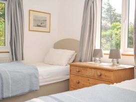 A bedroom with two beds and a dresser at Seaworthy in Daymer Bay