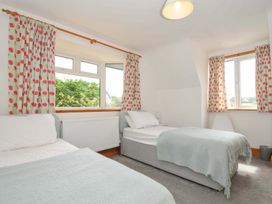 A bedroom with two beds and windows at Seaworthy in Daymer Bay